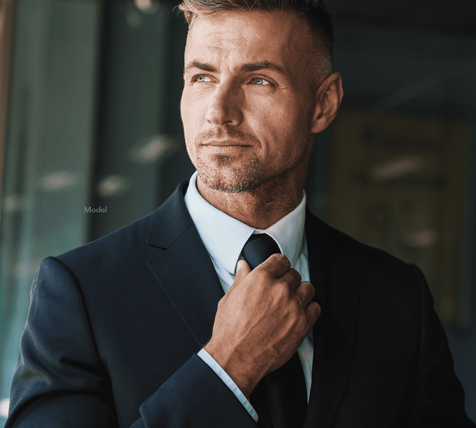 Man in a suit adjusting his tie