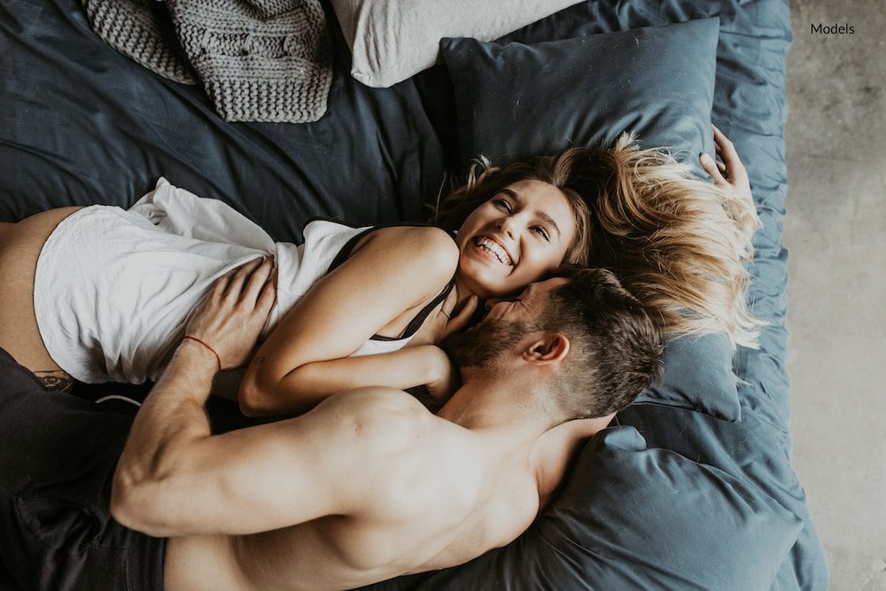 Happy, intimate couple lying in bed.