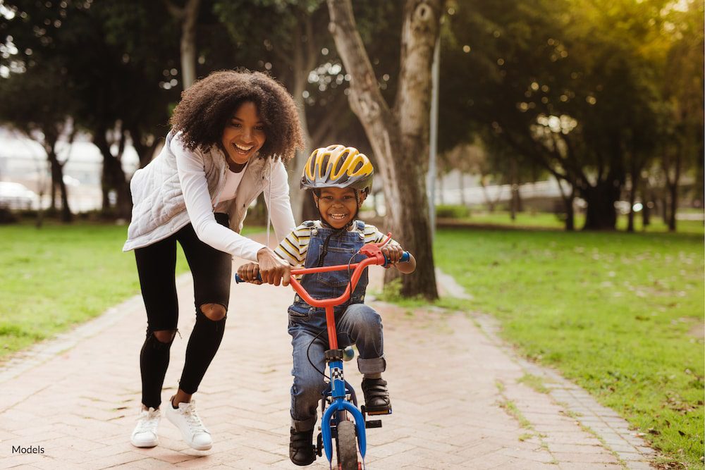 Women being active with her young son riding a bike.