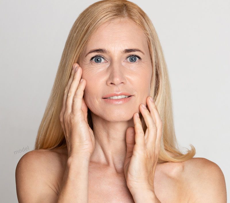 Blond woman touching her face