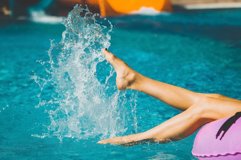 Woman splashing her legs in pool.