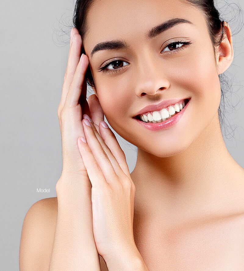 Young woman touching her face