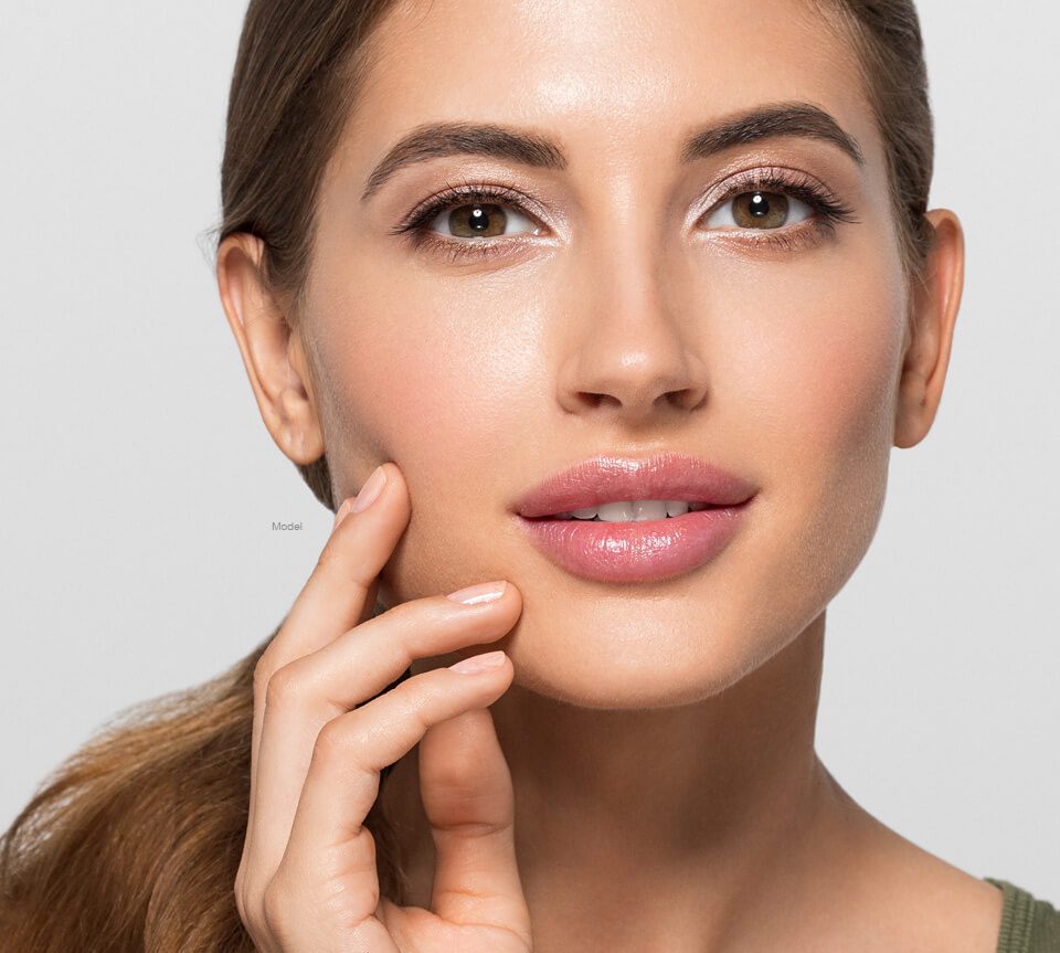 Younger woman touching her face