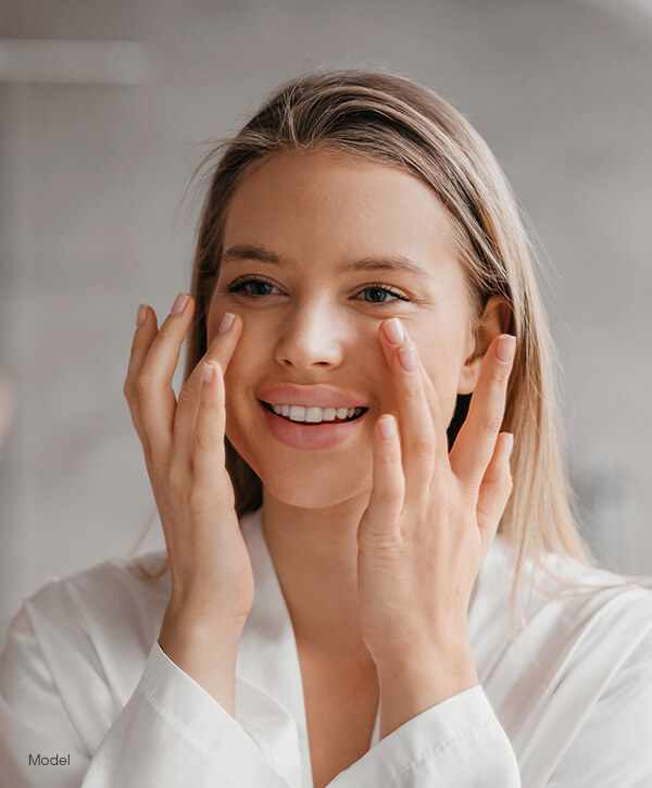 Young woman touching her face